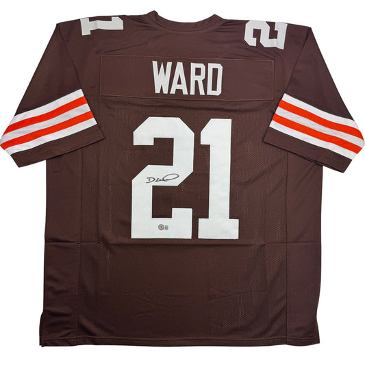 Brown Cleveland Browns football jersey number 21 with "WARD" nameplate and autographed signature, displayed flat on white background.