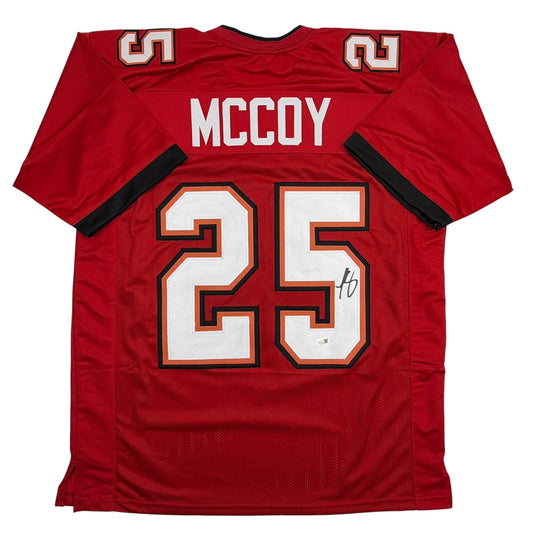 Red Tampa Bay football jersey displaying "McCoy" and number 25 with white and orange trim, shown flat lay from back view.
