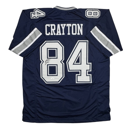 Back view of navy blue Dallas Cowboys football jersey number 84 with "CRAYTON" nameplate and white striping on sleeves.