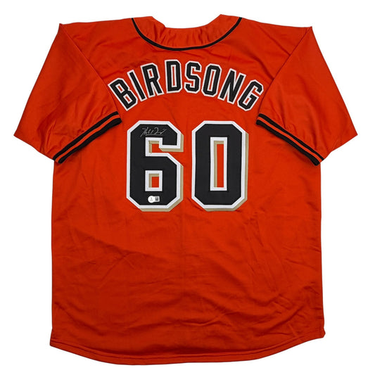 Red baseball jersey with "BIRDSONG" and number 60 in black and white on back, displayed flat.
