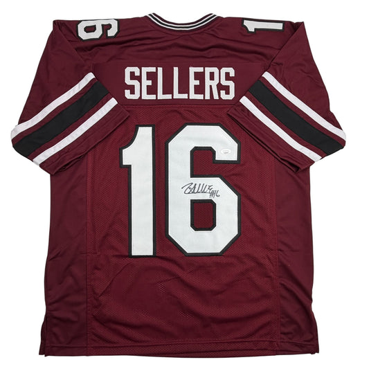 Front view of maroon college football jersey with "SELLERS" and number "16" in white, featuring white and black sleeve stripes and autographed signature.