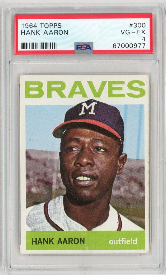 Front of 1964 Topps Hank Aaron baseball card in PSA graded holder showing player portrait in Braves uniform with green text border.