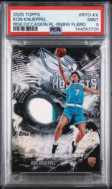 PSA-graded rookie basketball card featuring Kon Knueppel in blue uniform with embedded white player-worn relic swatch.