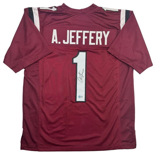 Back view of maroon college football jersey with "A. JEFFERY" and number "1" in white, featuring autograph and Beckett authentication seal.