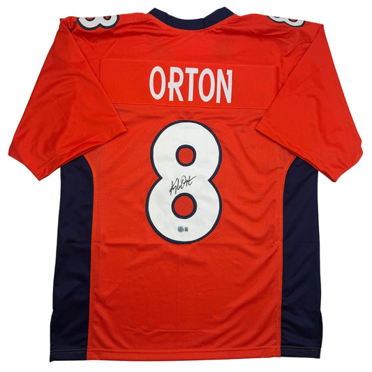 Back view of red Denver Broncos jersey number 8 with "ORTON" nameplate and autographed number, navy side panels.