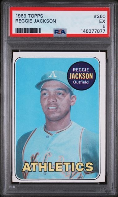 Front view of graded 1969 Topps Reggie Jackson rookie card in PSA case showing player portrait on light blue background with red label.