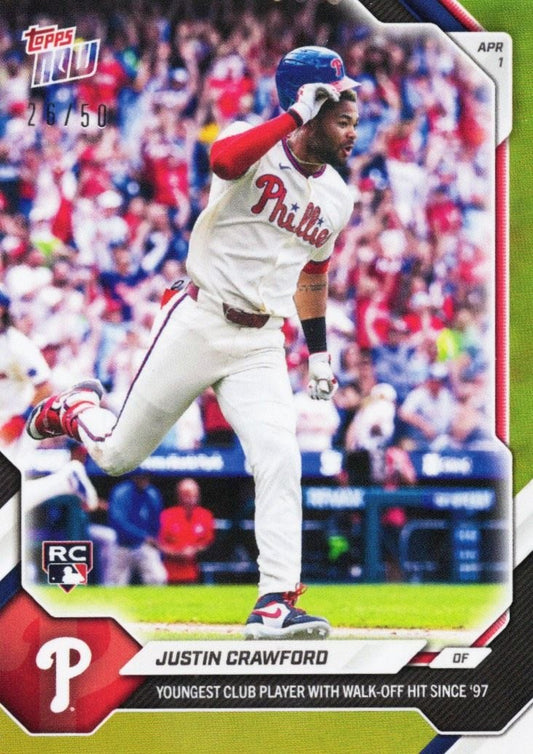 Baseball card front showing Justin Crawford in red and white Phillies uniform mid-swing during game, with crowd in background and gold foil border.