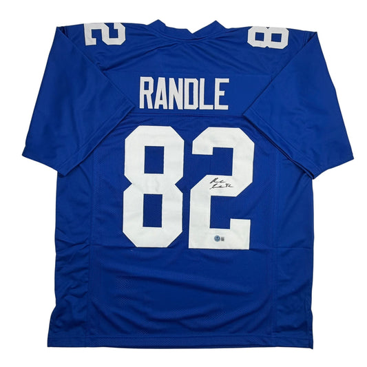 Blue New York Giants football jersey number 82 with "RANDLE" nameplate and autographed signature, laid flat front view.