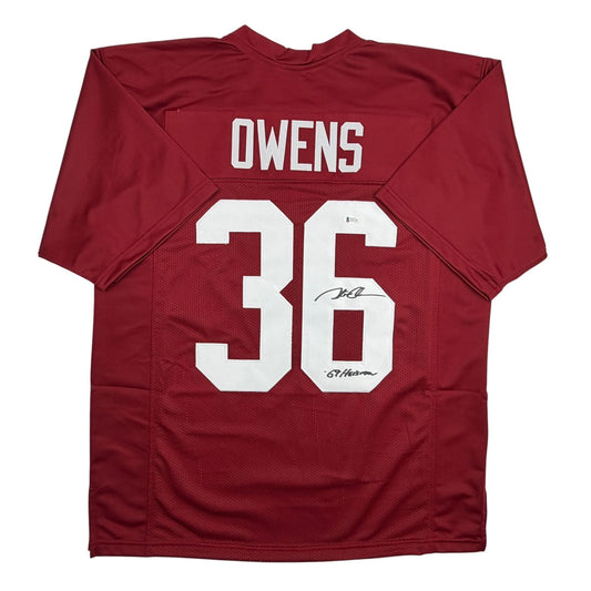 Flat lay back view of maroon Oklahoma football jersey with white "OWENS 36" lettering and visible autographed signatures on the number.
