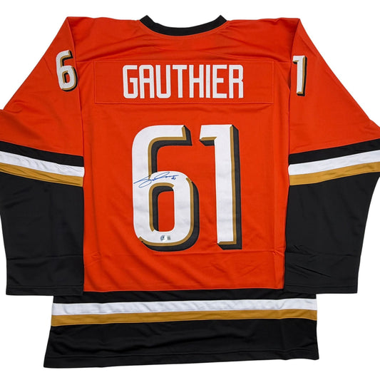 Back view of orange and black Anaheim Ducks hockey jersey with "GAUTHIER" and number "61" in white and gold lettering, signed across the chest number.