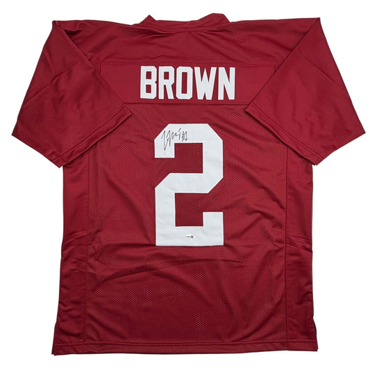 Flat lay back view of signed crimson Alabama football jersey number 2 with Brown nameplate and white numerals on mesh fabric.