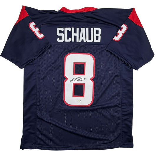 Navy blue football jersey with red trim displaying "SCHAUB" and number 8, signed across the chest, laid flat against white background.