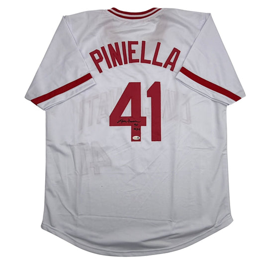 White baseball jersey with red "PINIELLA" and "41" printed on back, featuring red neck trim and sleeve stripes, with autograph visible on number.