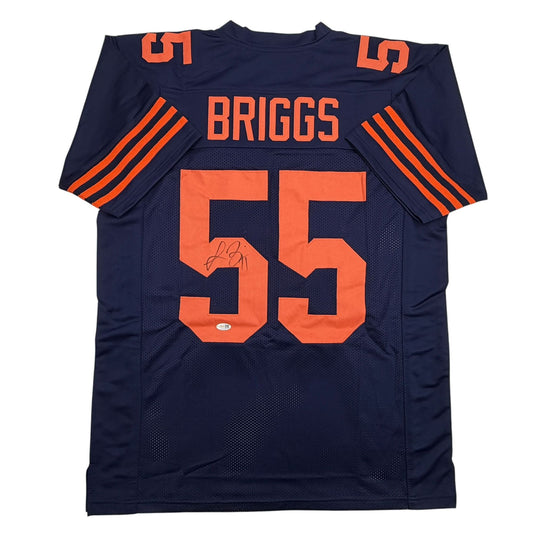 Navy blue Chicago Bears Color Rush jersey number 55 with orange lettering reading "BRIGGS" and an autographed signature on the chest, displayed flat lay front view.
