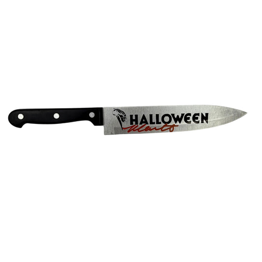 Chef's knife with black handle and stainless steel blade printed with "HALLOWEEN" text and Michael Myers silhouette graphic.