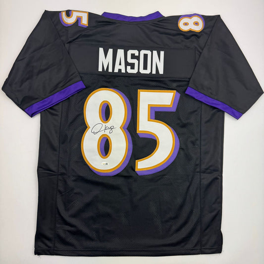 Back view of black Baltimore Ravens jersey number 85 with "MASON" nameplate, purple and gold trim, autographed on chest number.