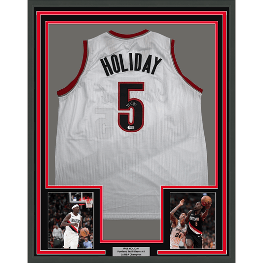 White Portland Trail Blazers basketball jersey number 5 with "HOLIDAY" nameplate, displayed in frame with red and black borders and two action photos below.
