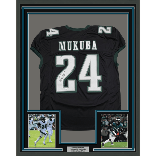 Framed black Philadelphia Eagles #24 jersey signed by Andrew Mukuba, displayed with two action photos and nameplate below.