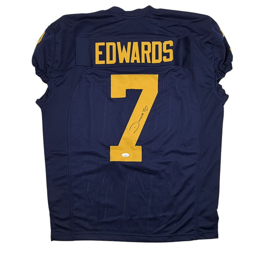 Back view of navy blue Michigan football jersey with "EDWARDS" and number "7" in gold, featuring visible autograph on the number.
