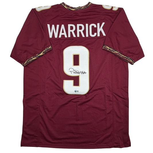 Maroon Florida State football jersey number 9 with "WARRICK" printed across chest, displayed flat against white background, showing front view with autographed number and gold shoulder trim.