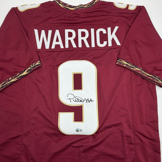 Front view of maroon FSU football jersey with "WARRICK" and number 9 in white, featuring an autographed signature on the number patch.