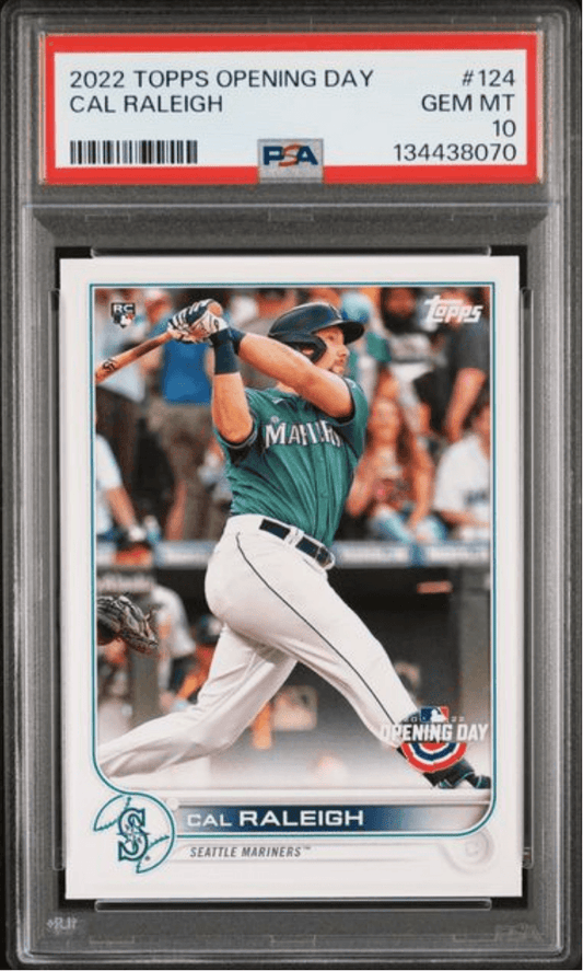 PSA-graded baseball card in plastic holder showing Cal Raleigh in Seattle Mariners uniform mid-swing, with red grading label and certification number visible.