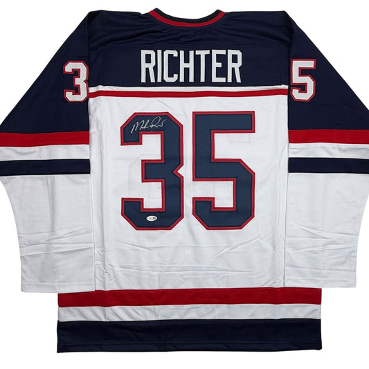 Back view of white hockey jersey with navy sleeves, red and navy number 35, "RICHTER" nameplate, and autographed signature.