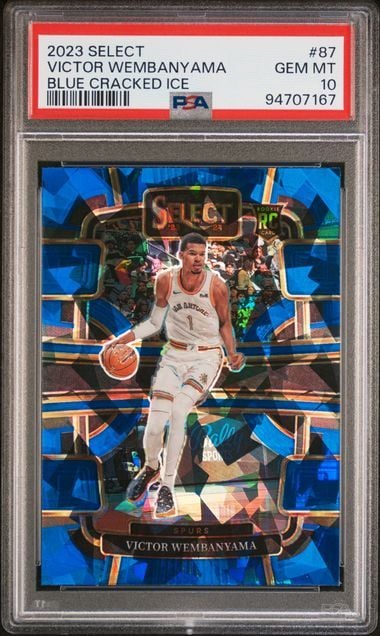 Front of graded trading card featuring Victor Wembanyama in white uniform against blue cracked ice background, enclosed in clear PSA case.
