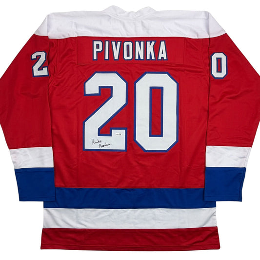 Back view of red, white, and blue hockey jersey with "PIVONKA" and number 20 in white and blue lettering, with handwritten signature below the number.