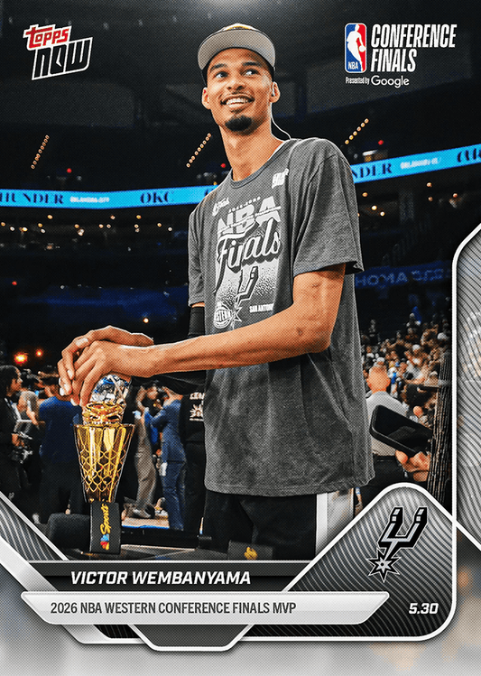 Victor Wembanyama holding the Conference Finals MVP trophy wearing gray NBA Finals shirt and tan cap in arena.