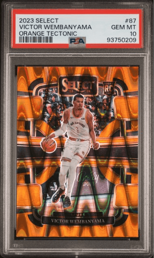 PSA-graded trading card in clear plastic case showing Victor Wembanyama in white uniform against orange tectonic background with red label visible.