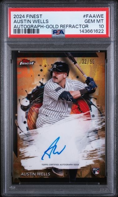 Graded baseball card showing Austin Wells in pinstriped uniform with blue autograph on gold-refractored surface, numbered 32/50.