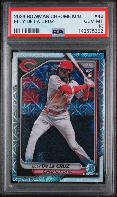 PSA-graded 2024 Bowman Chrome baseball card of Elly De La Cruz in red Cincinnati Reds uniform, shown in protective case with red label.