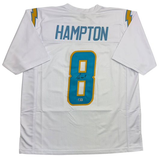 White Los Angeles Chargers football jersey with blue number 8, gold trim, "Hampton" nameplate, and autograph, displayed flat lay front view.