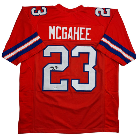 Red football jersey with white "MCGAHEE" text and blue number 23, displayed flat against white background, front view showing autographed signature on chest.