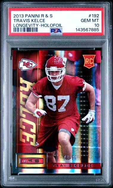 PSA-graded 2013 Panini rookie card of Travis Kelce #192 in protective case, showing player in red Chiefs uniform with holographic design elements.
