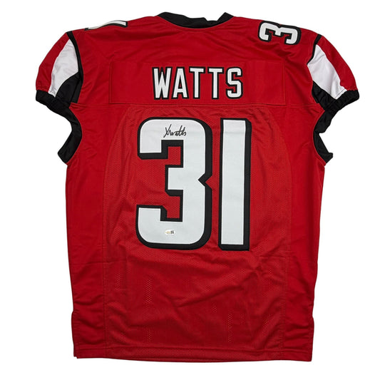 Back view of red Atlanta Falcons pro cut football jersey number 31 with "Watts" nameplate and autographed signature on white number.