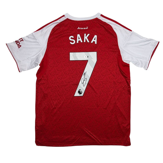 Back view of red and white Arsenal jersey with "SAKA" and number 7 with signature across the chest.