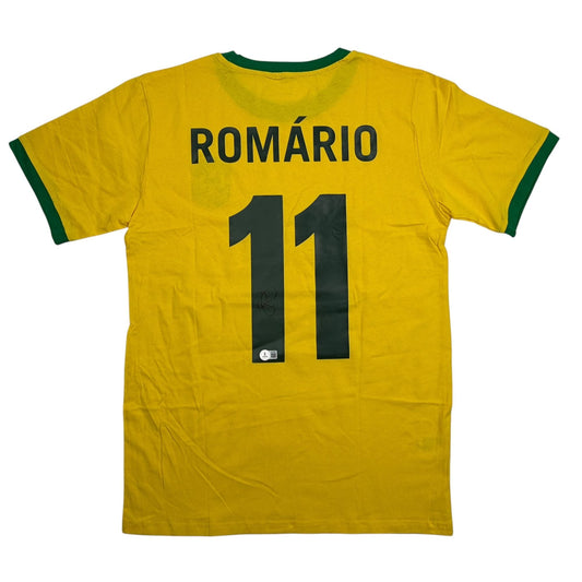 Back view of yellow Brazil soccer jersey with green trim, displaying "ROMÁRIO" and number 11 in dark green with visible autograph.