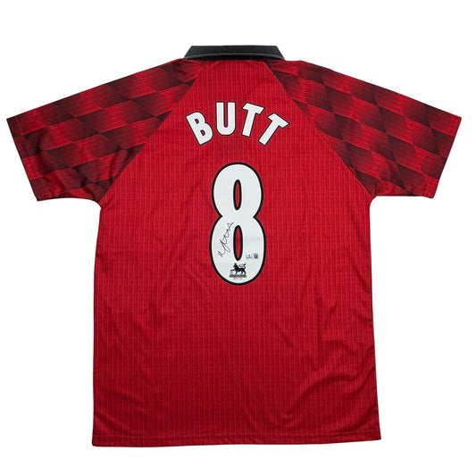 Back view of red Manchester United jersey number 8 with "BUTT" nameplate and autographed number, black collar visible.