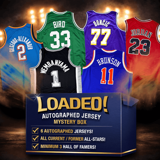 Six autographed NBA jerseys displayed against dramatic lighting: blue Gilchrist-Alexander #2, black Webaniamah #1, green Bird #33, purple Donci #77, blue Brunson #11, and red Jordan #23, above "LOADED! Autographed Jersey Mystery Box" text with product details.