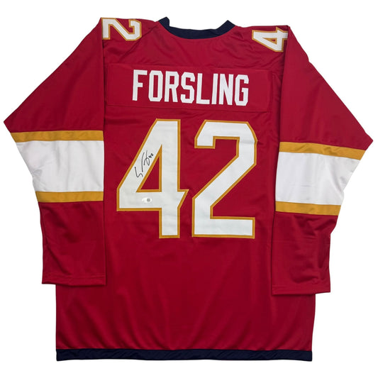 Red hockey jersey with white and gold stripes, number 42, "FORSLING" nameplate, displayed flat on white background.