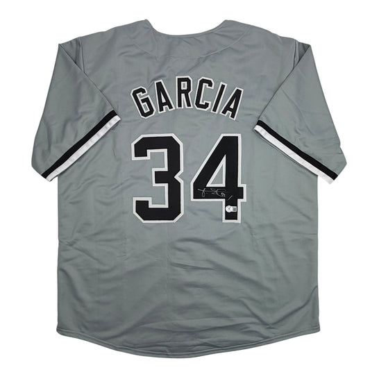 Back view of grey baseball jersey with "GARCIA" and number 34 in black and white lettering, showing black and white striped sleeves.