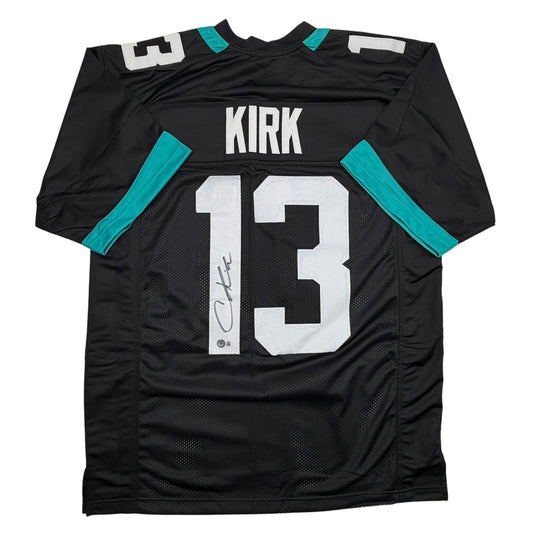 Black Jacksonville Jaguars jersey number 13 with "KIRK" nameplate and autograph, displayed flat against white background.