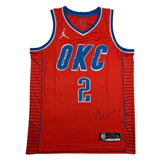 Red Oklahoma City Thunder basketball jersey number 2 with blue trim displayed flat, showing front view with autograph signature visible.
