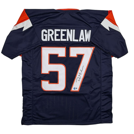 Back view of navy blue football jersey with "GREENLAW" and number "57" in white and orange, featuring signed autograph on number.