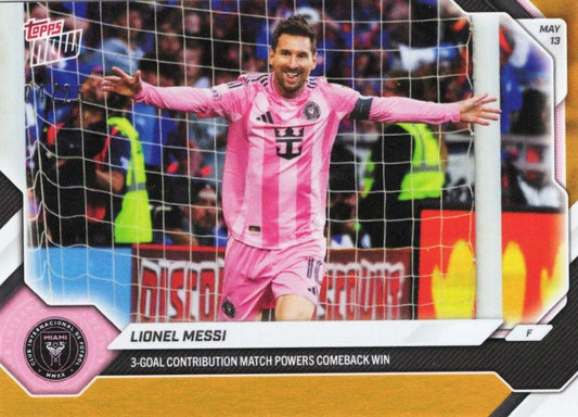 Lionel Messi in pink Inter Miami jersey celebrating with arms spread wide in front of goal net, Topps trading card with orange foil border and match details text.