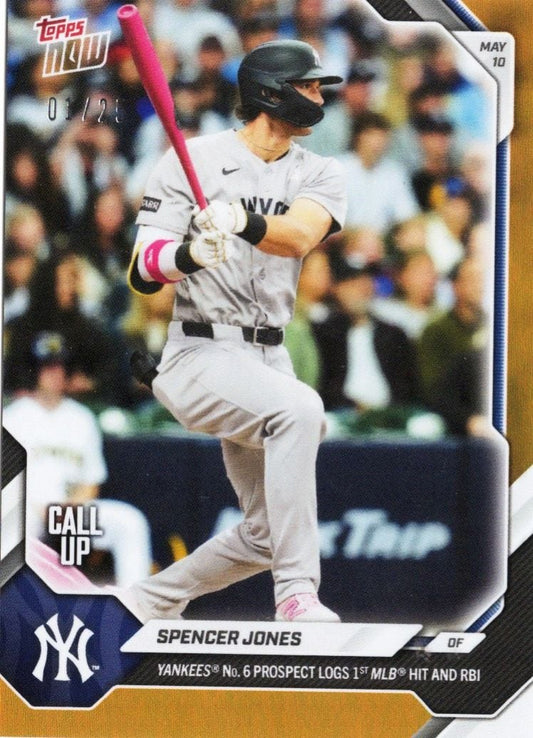 Spencer Jones in batting stance wearing Yankees gray uniform with pink bat, mid-swing during game action on orange foil baseball card.