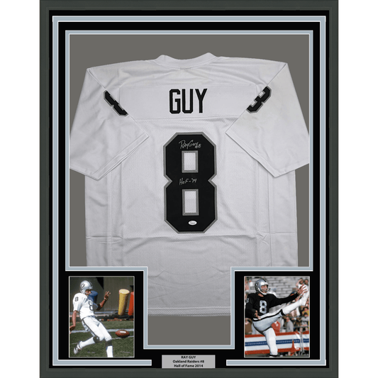 White framed Oakland Raiders #8 jersey signed by Ray Guy with HOF 14 inscription, displayed with two accompanying photographs.