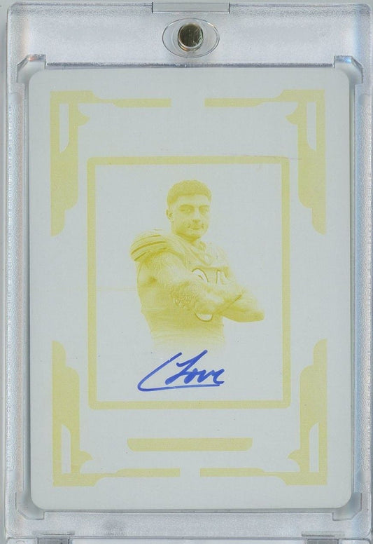 Yellow printing plate showing rookie football player in shoulder pads with blue autograph, encased in protective holder.